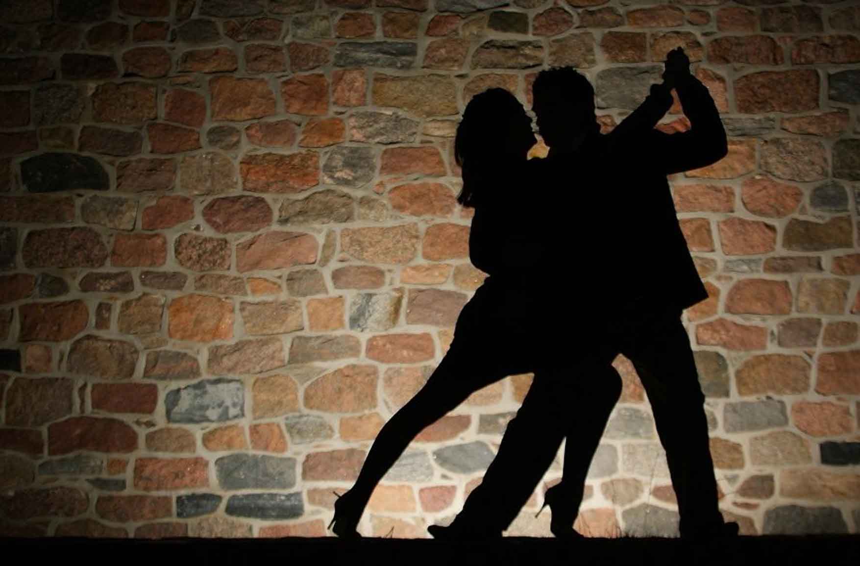 Быть мужчиной стеной. Танец теней. Танцующие тени. Пара танцует в темноте. Тень танцующей пары.