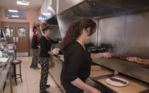 The 3 women of the family have the grill  under their full control.